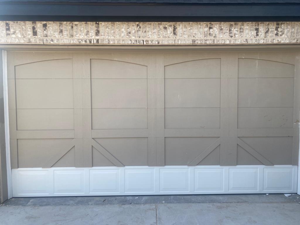 New carriage-style garage door on a stone home