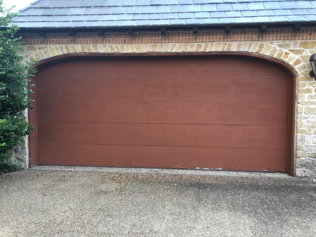 New wood-look garage door installed in a stone arch