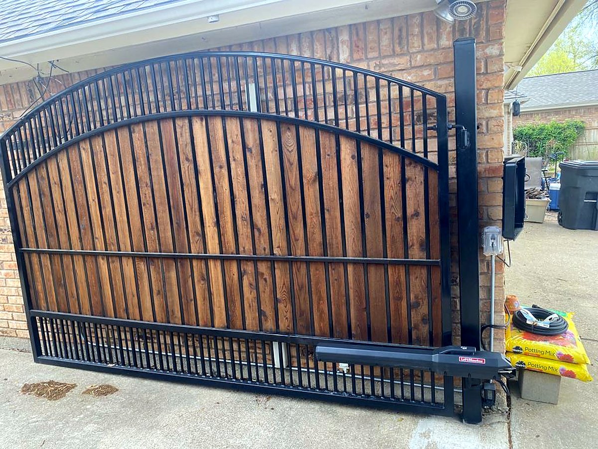 Custom arched wood and steel automatic driveway gate installed by Garage Tec