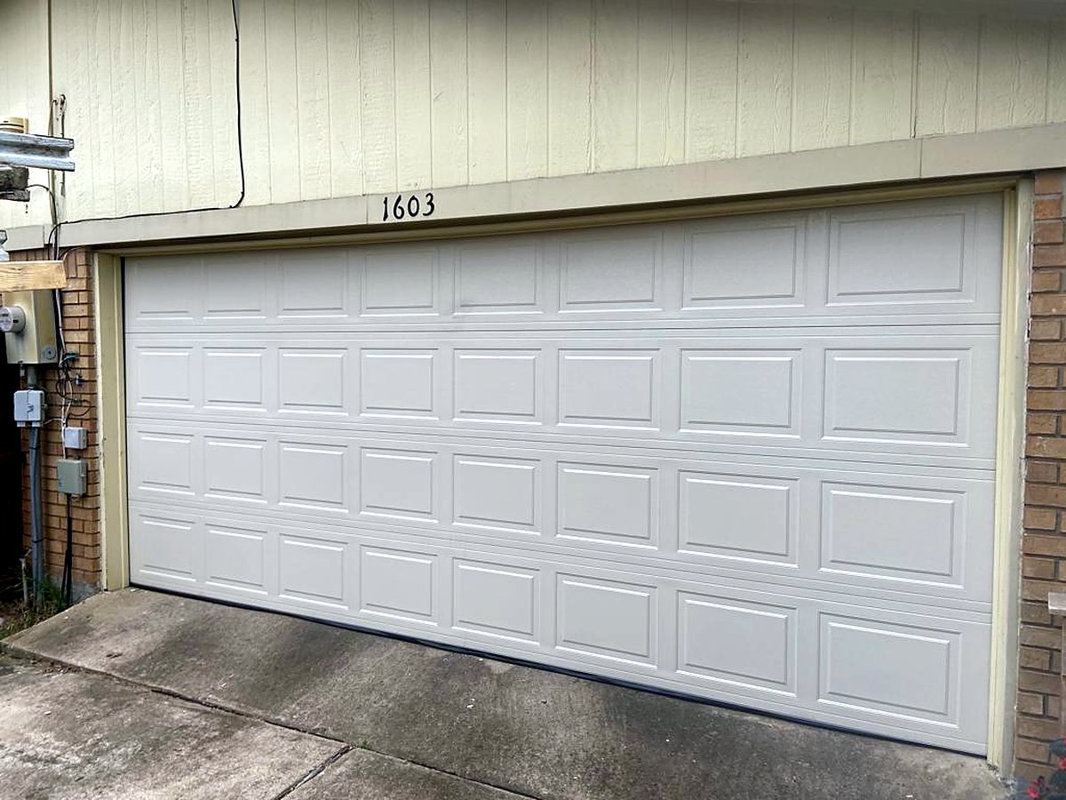 White raised-panel garage door on a home White raised-panel garage door on a home