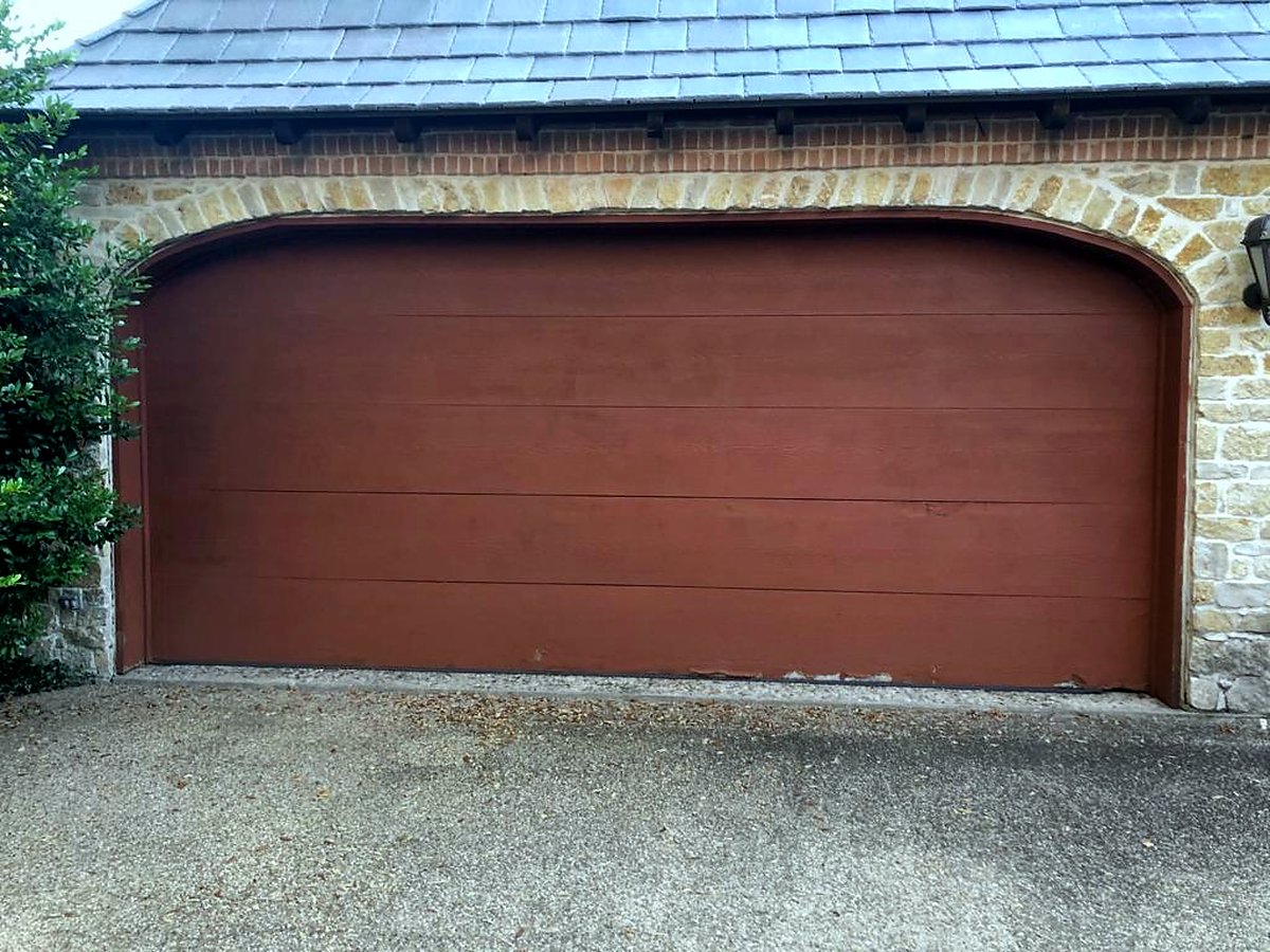 Wood-look designer garage door in a stone arch Wood-look designer garage door in a stone arch