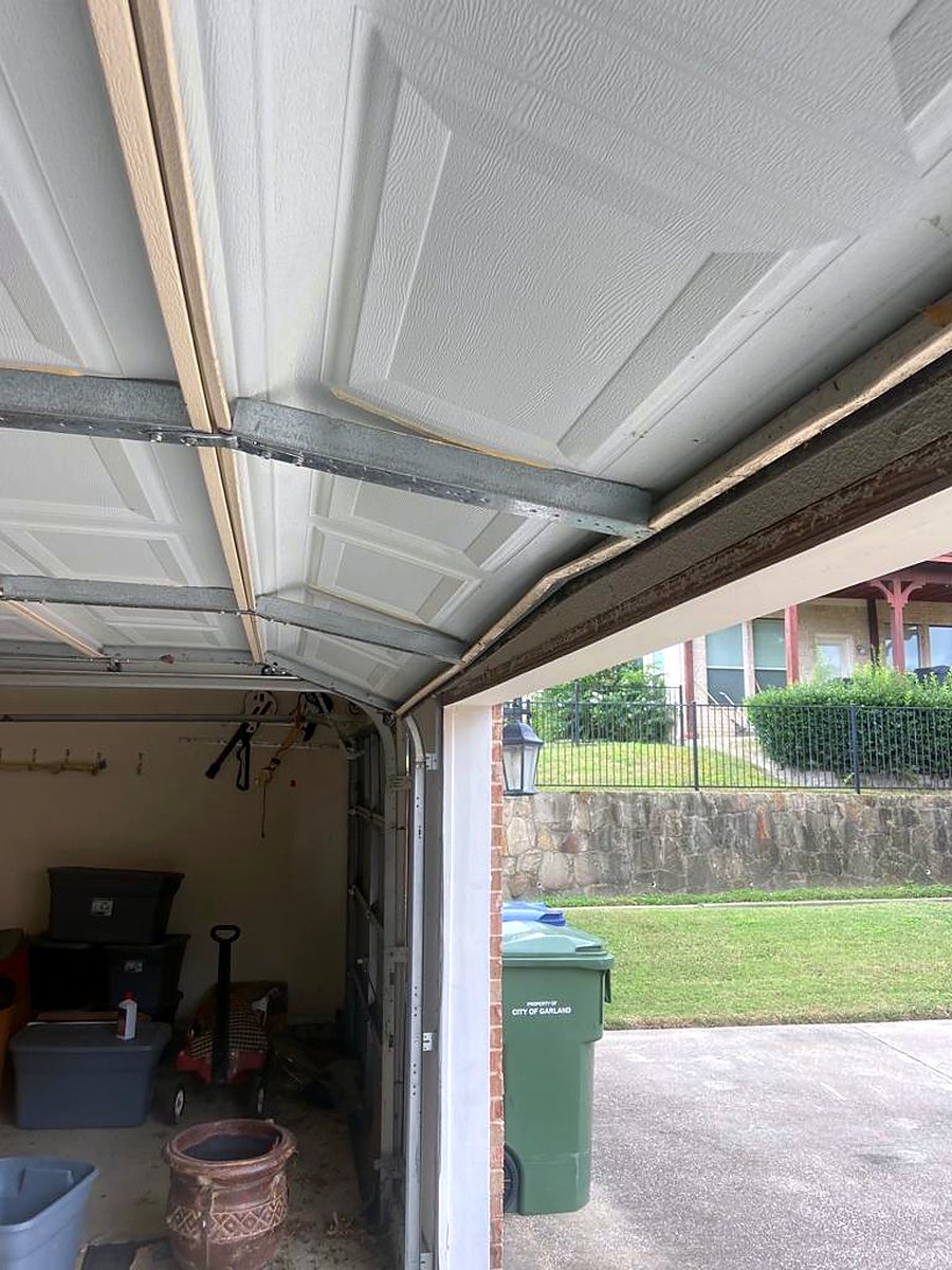 Older garage door off its track, a candidate for replacement Older garage door off its track, a candidate for replacement